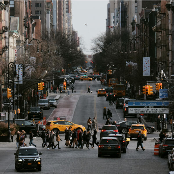 Bronx NYC street with cars and people.